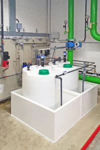Dosierbehälter mit Auffangwannen, Chemikalien-Tankanlage im Industrie-Betrieb
